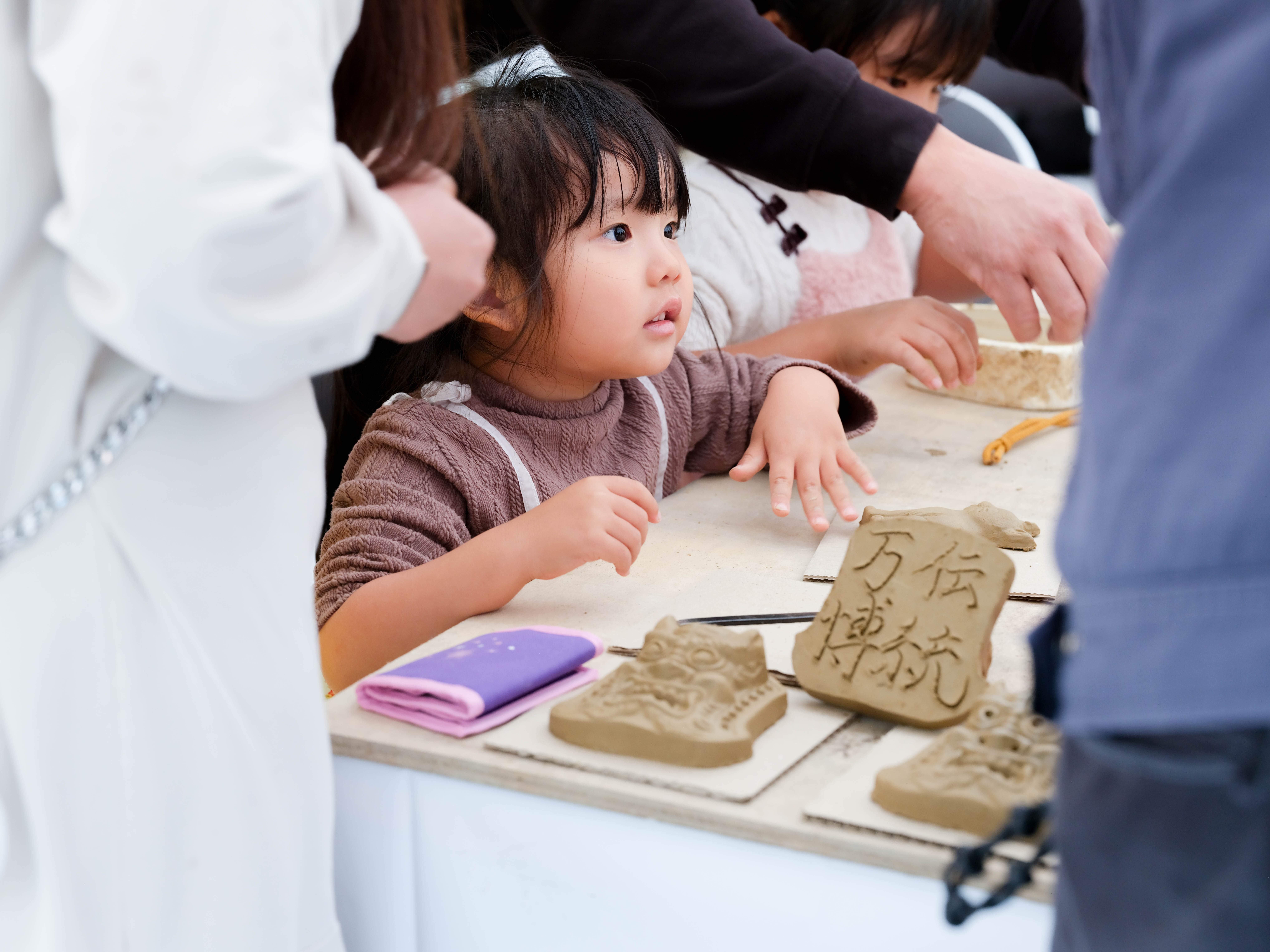 瓦作り体験で粘土をこねる女の子